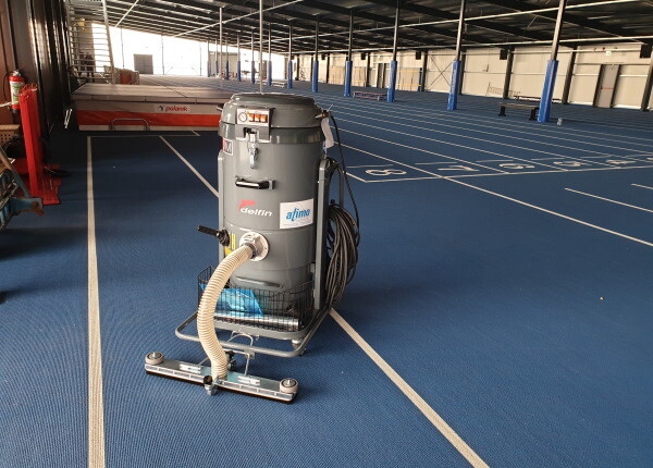 Gymzaal of atletiekbaan schoonzuigen met industriële stofzuiger